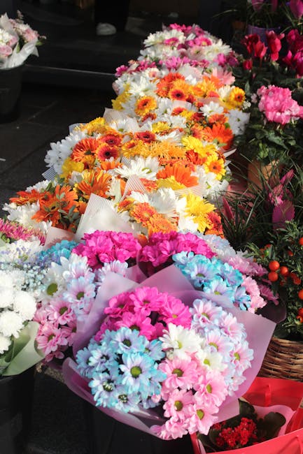 A display of vibrant floral bouquets arranged for flower delivery or gifting, featuring a variety of fresh flowers including pink and white daisies, orange and yellow gerbera daisies, and other colorf